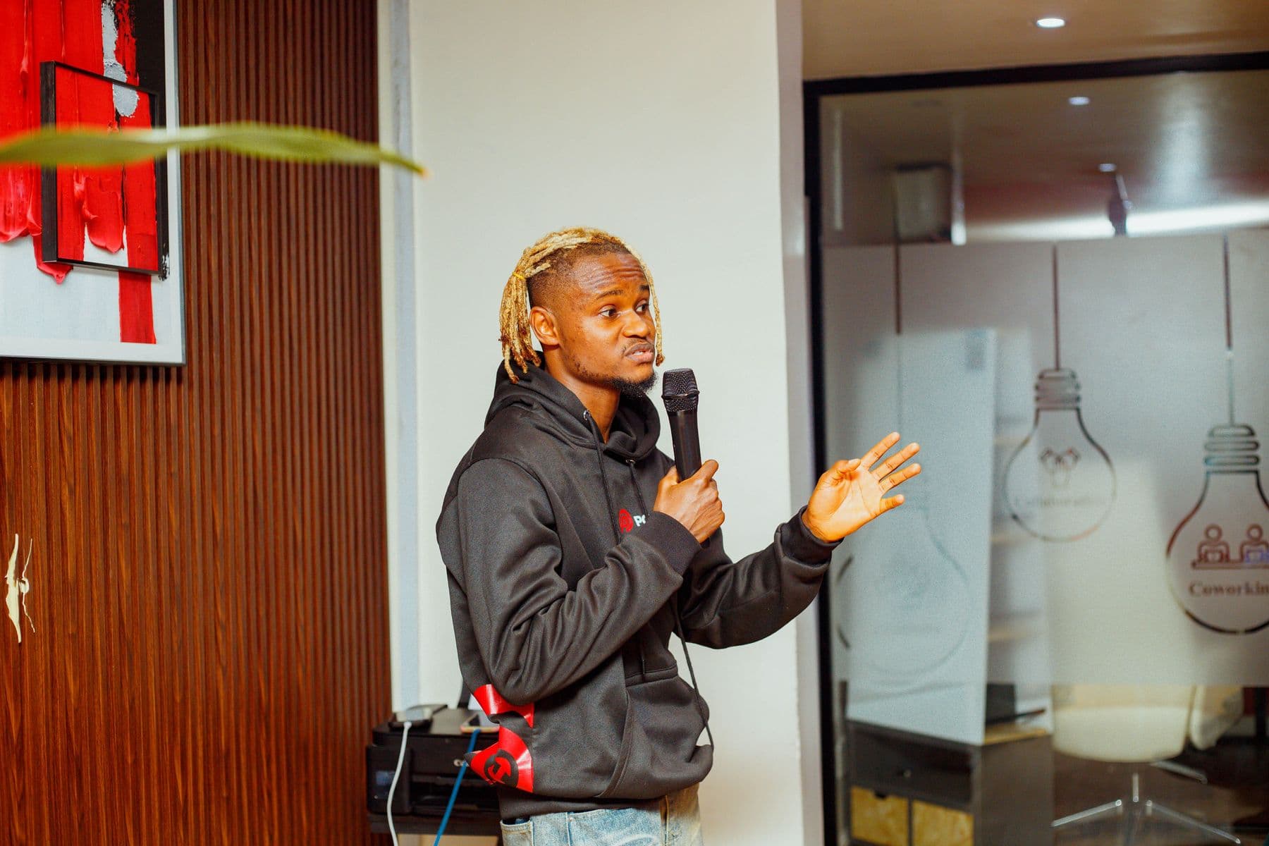 A founder speaks to the room, mic in hand
